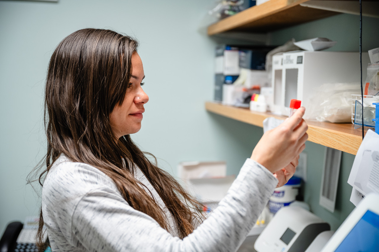 a medical professional woman looking at a test tube